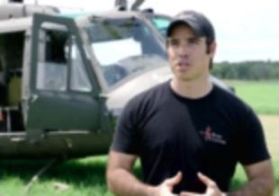 Veteran beside a UH-1 Huey helicopter